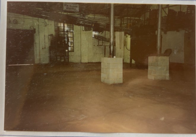 Original archive photograph: two new blockwork piers built around steel columns on the factory floor of the Croydon premises, protecting them from forklift damage