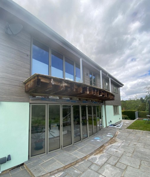 Balcony stripped back to bare, rotted joists before rebuilding
