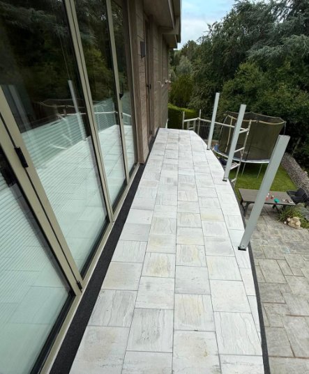 Tiled balcony surface alongside the full-height glazing