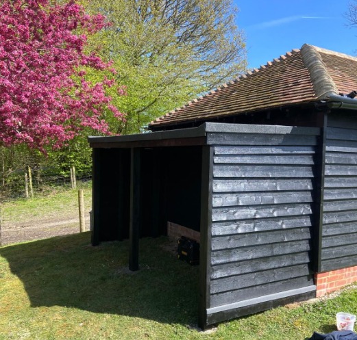 Timber outbuilding with black cladding and open front, built in Rolvenden, Kent